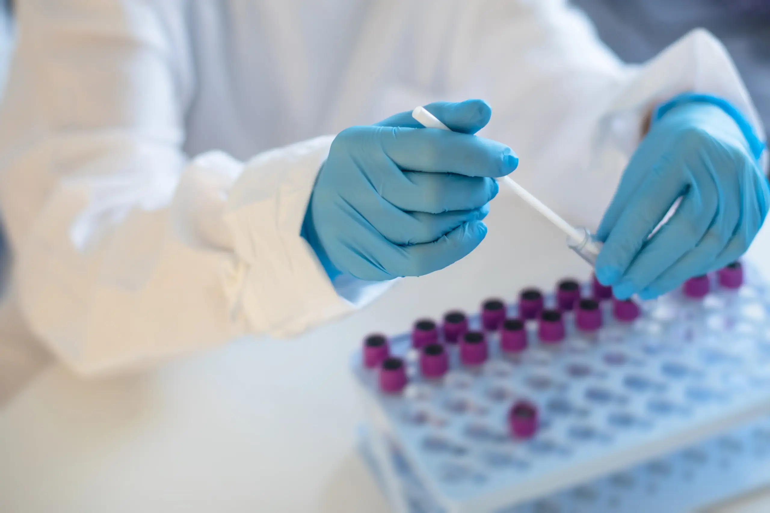 lab testing with person handling tubes scaled.jpeg scaled